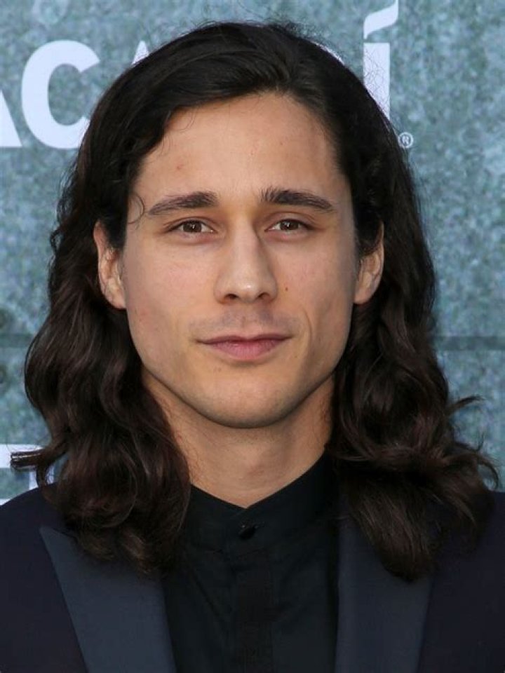 Peter Gadiot looking handsome in white t-shirt with black glasses.